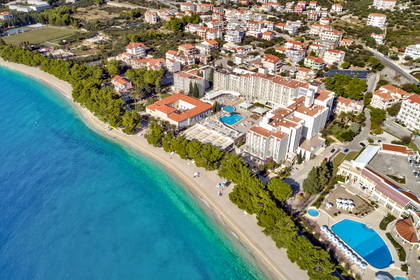 Hotel przy plaży z turkusową wodą, widok z lotu ptaka.