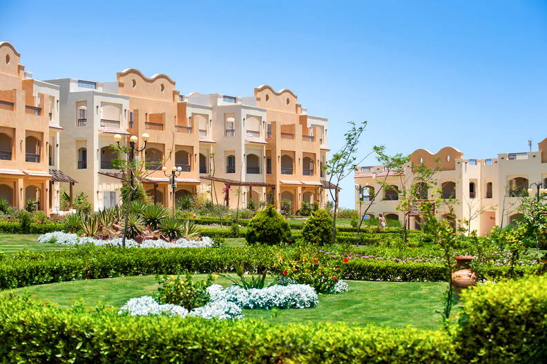 Kompleks wypoczynkowy w ciepłych kolorach z zadbanym ogrodem.