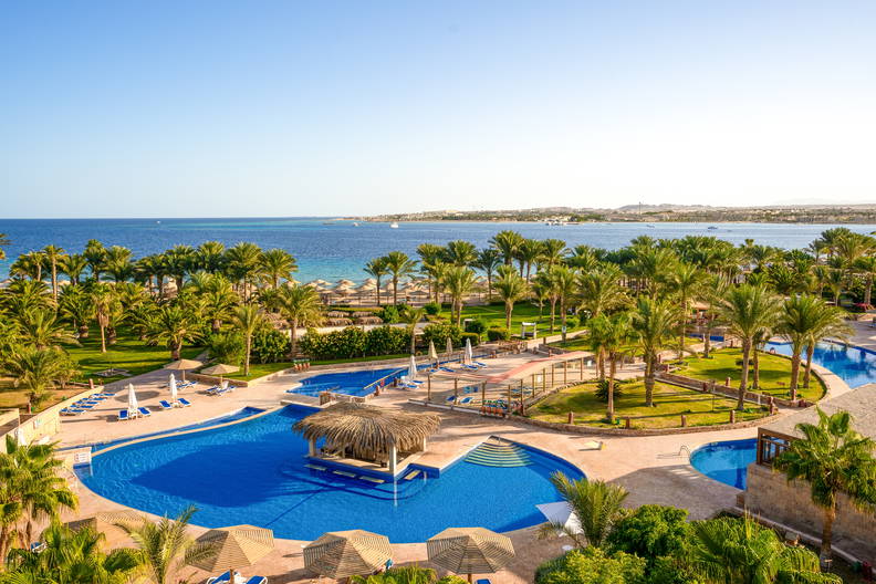 Hotel z basenami i palmami nad morzem.