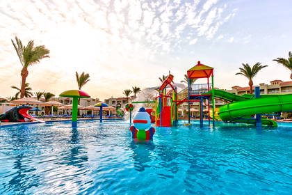 Aquapark z kolorowymi zjeżdżalniami i basenem pełnym atrakcji wodnych.