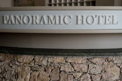 Recepcja hotelu Panoramic z elementami kamiennymi.