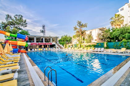 Basen z leżakami i zjeżdżalnią wodną przy hotelu.