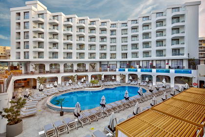 Hotel z basenem i leżakami.