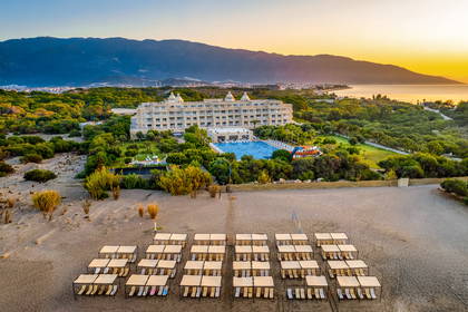 Hotel z basenem i plażą z parasolami, widok z lotu ptaka.