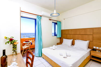 Pokój hotelowy z balkonem i widokiem na morze.