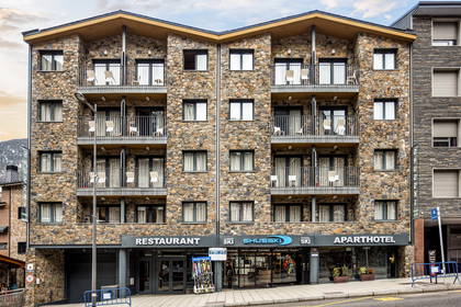 Kamienny budynek aparthotelu z balkonami. Na parterze mieszczą się restauracja i sklep narciarski.