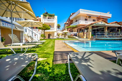 Basen hotelowy z leżakami i parasolami.