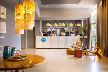Hol hotelowy z recepcją i lampami dekoracyjnymi.