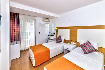 Pokój hotelowy z dwoma łóżkami i telewizorem.