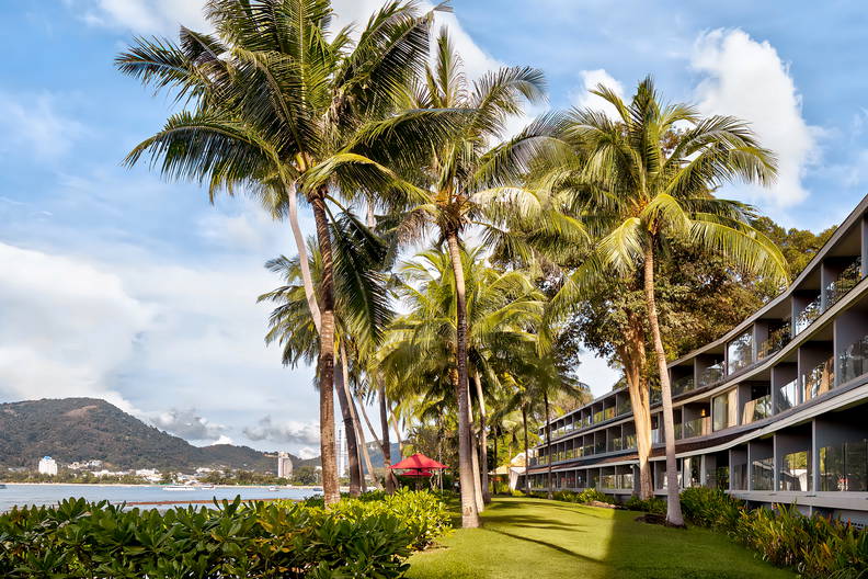 Hotel otoczony palmami i zielenią.