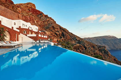 Basen bez krawędzi z widokiem na budynki na klifie, Santorini.