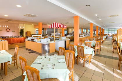 Restauracja z nakrytymi stołami i bufetem.