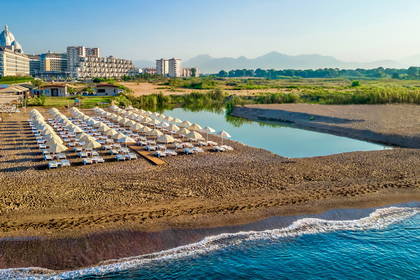 Plaża z leżakami, morze i hotele widziane z góry.