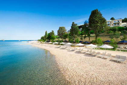 Plaża z leżakami i parasolami w słoneczny dzień.