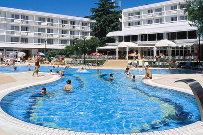 Basen hotelowy, w którym pływają ludzie. Słoneczny dzień.