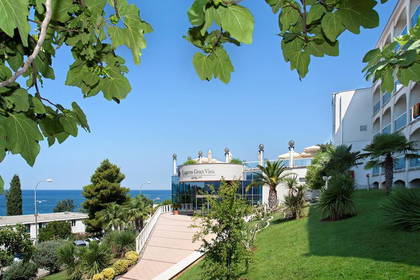 Hotel Laguna Gran Vista z widokiem na morze, otoczony zielenią.
