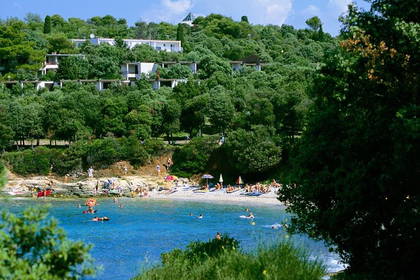 Plaża z ludźmi i budynkami w tle.