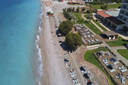Plaża z turkusową wodą i leżakami, widok z lotu ptaka.