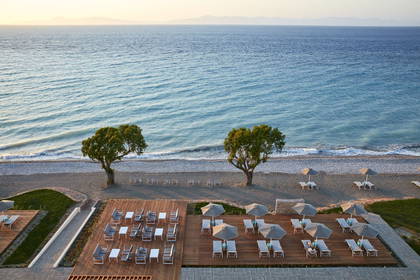Plaża z lotu ptaka. Widoczne leżaki i parasole.