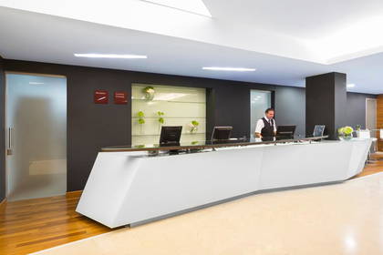 Recepcja hotelowa i pracownik obsługi.