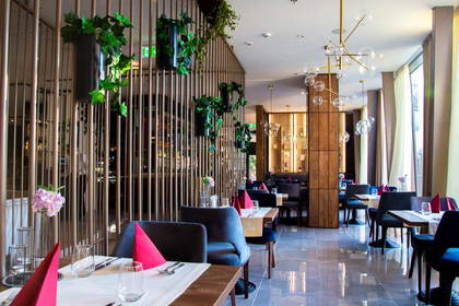 Elegancka restauracja z roślinami i stylowym oświetleniem.