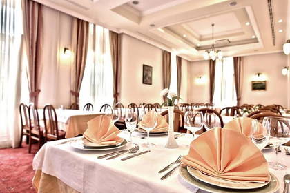 Sala restauracyjna z nakrytymi stołami.