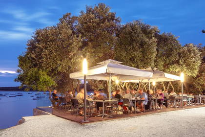 Restauracja na zewnątrz z widokiem na zatokę o zmierzchu.