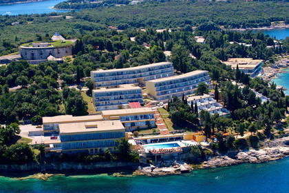 Hotel otoczony zielenią, położony nad morzem. Widok z lotu ptaka.