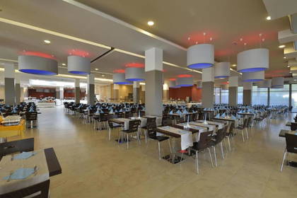Duża restauracja hotelowa z nakrytymi stołami.