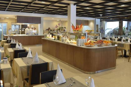 Restauracja z bufetem, nakryte stoły i kucharze.