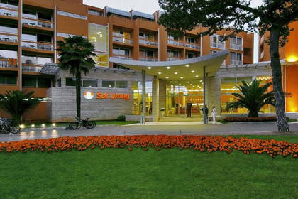 Wejście do hotelu Sol Umag z zadbanym trawnikiem i kwiatami.