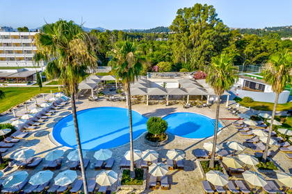 Hotel z basenem i palmami, widok z góry.