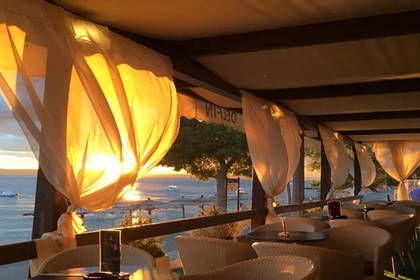 Restauracja na plaży z widokiem na zachodzące słońce.
