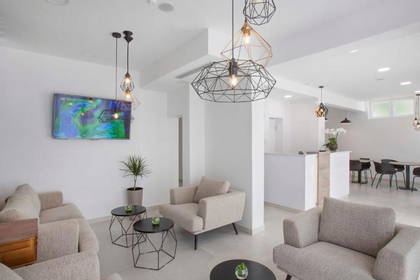 Nowoczesne lobby hotelowe z jasnymi sofami i geometrycznymi lampami.