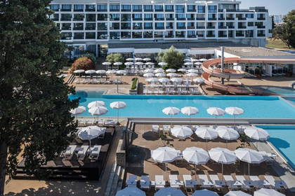 Hotel z basenem i parasolami, widok z góry.