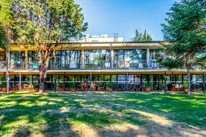 Dwupiętrowy budynek z restauracją na zewnątrz.