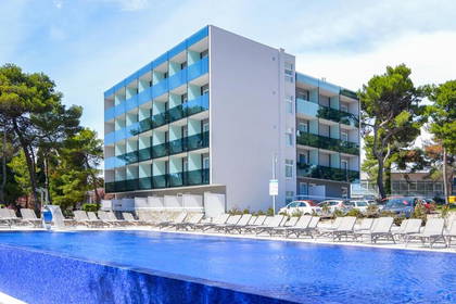 Hotel z basenem i leżakami do opalania.