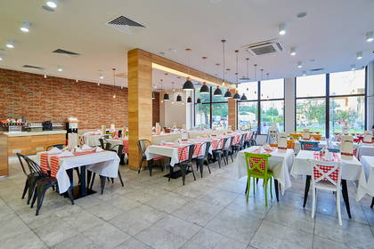 Restauracja. Nakryte stoliki i duże okna.