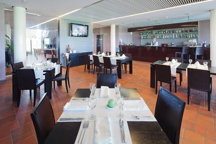 Wnętrze restauracji: nakryte stoły i bar.