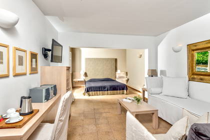 Pokój hotelowy z łóżkiem, sofą i biurkiem.
