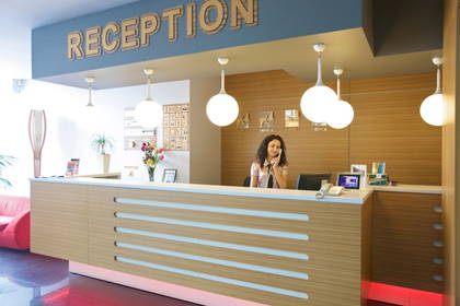 Recepcja hotelowa. Kobieta rozmawia przez telefon.
