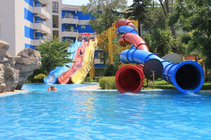 Aquapark z kolorowymi zjeżdżalniami i basenem.