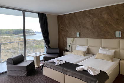 Pokój hotelowy z dwoma łóżkami i widokiem na morze.