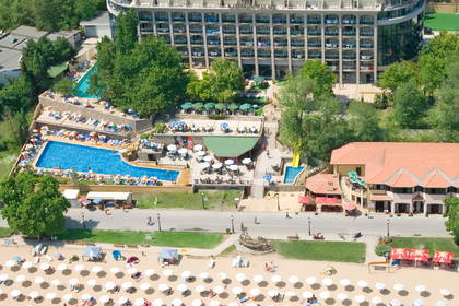 Hotel z widokiem na morze i plażę pełną parasoli (widok z lotu ptaka).