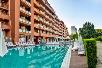 Hotel z basenem i leżakami.