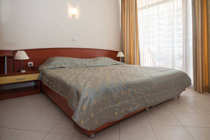 Pokój hotelowy z dużym łóżkiem i balkonem.