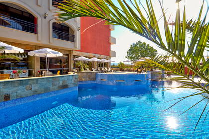 Kompleks hotelowy z basenem i palmami.