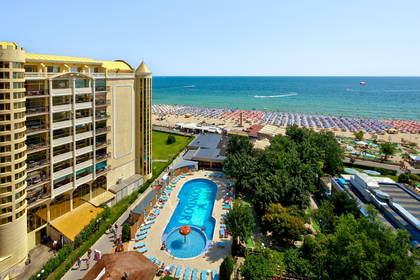 Widok z góry na hotel z basenem, plażę i morze.