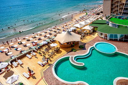 Widok z góry na plażę, basen i budynek hotelu.