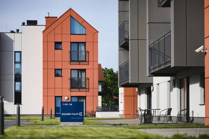 Nowoczesny budynek Golden Tulip z balkonami otoczony zielenią.